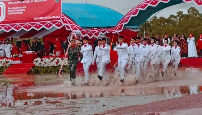 Diguyur Hujan, Lumpur dan Genangan Air Tak Surutkan Niat Paskibra Kapoiala Kibarkan Sang Saka Merah Putih